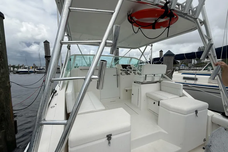Slide: The Image of 1998 Cabo 31 Express boat interior with seating and helm, docked at marina. - 7