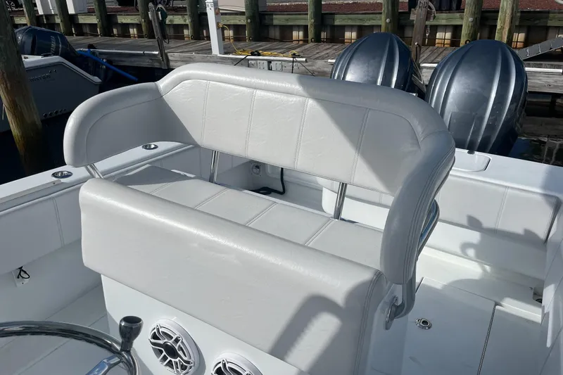 Slide: The Image of 2023 Contender 28 Tournament boat interior with cushioned seating and dual outboard motors. - 8