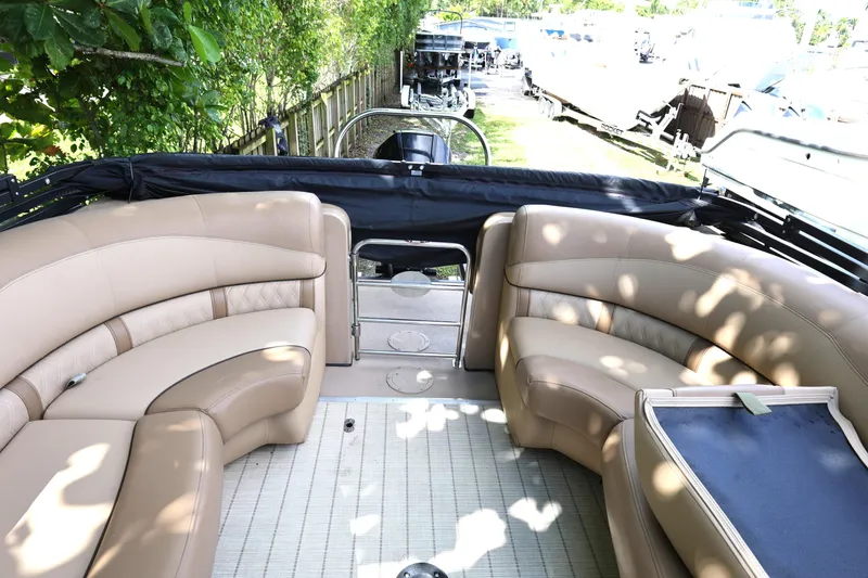 Slide: The Image of 2019 Harris Grand Mariner 250 boat interior with beige seating and outdoor setting. - 16