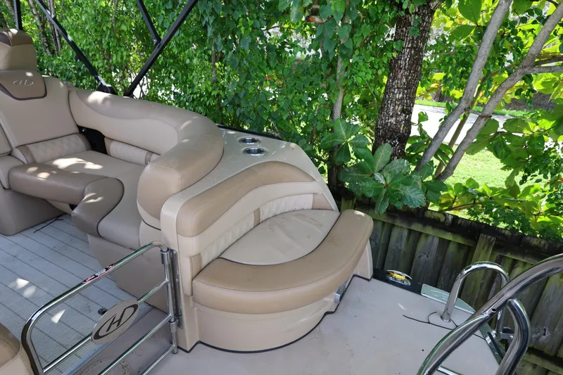 Slide: The Image of Luxurious seating on 2019 Harris Grand Mariner 250 pontoon boat, surrounded by lush greenery. - 21