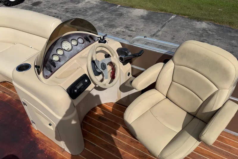 Slide: The Image of 2013 Berkshire 24RFC boat interior with beige captain's chair and control panel. - 10