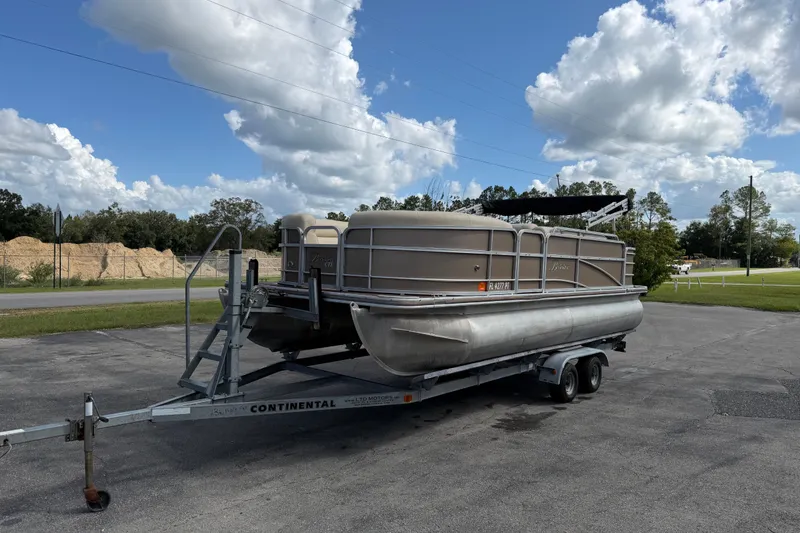 Slide: The Image of 2013 Berkshire 24RFC pontoon boat on trailer under a partly cloudy sky. - 4