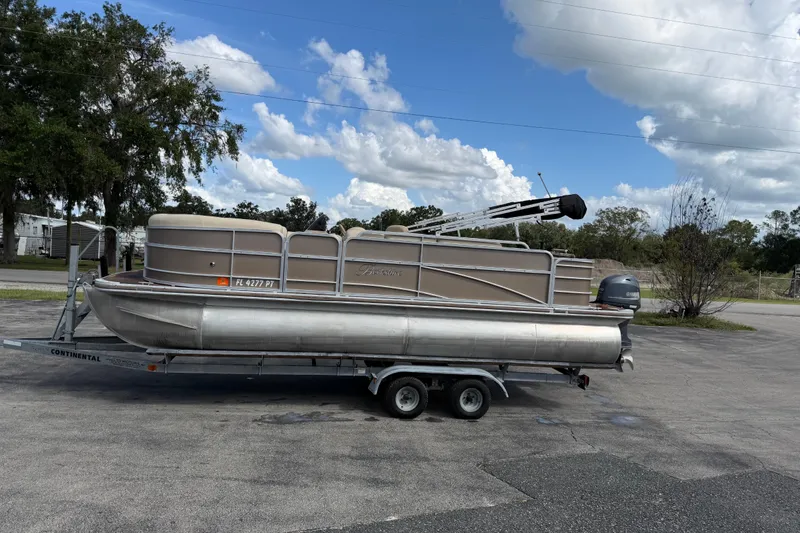 Slide: The Image of 2013 Berkshire 24RFC pontoon boat on trailer under a cloudy sky. - 5