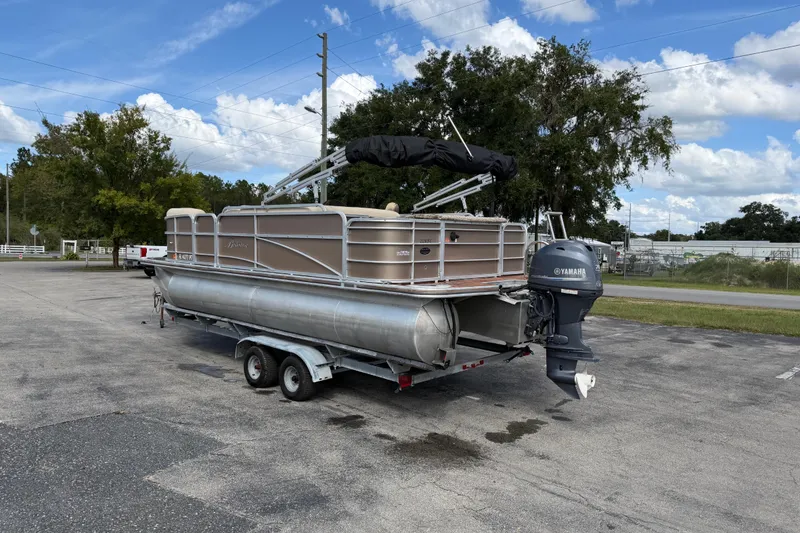 Slide: The Image of 2013 Berkshire 24RFC pontoon boat on trailer with Yamaha outboard motor, parked outdoors. - 6
