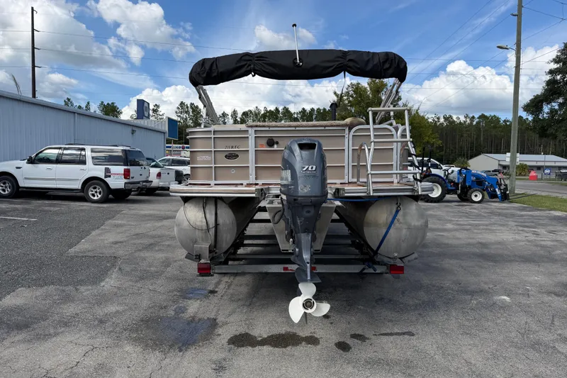 Slide: The Image of 2013 Berkshire 24RFC pontoon boat on trailer, parked outdoors under blue sky. - 7
