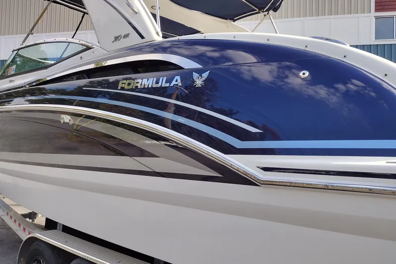 Slide: The Image of 2019 Formula 310 Bowrider boat with sleek design and reflective blue finish. - 10