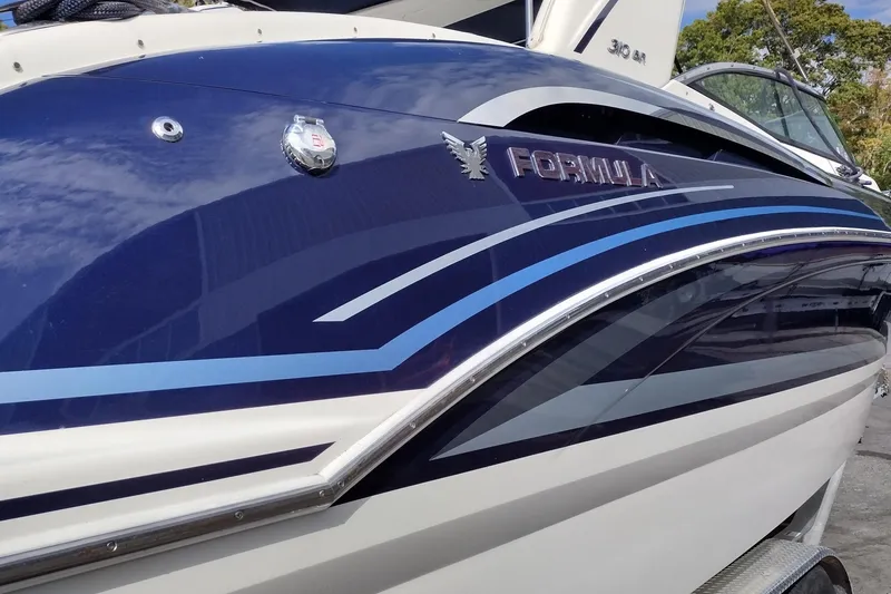 Slide: The Image of 2019 Formula 310 Bowrider boat with sleek blue and white design. - 11