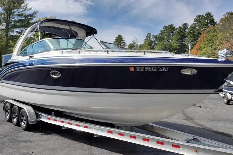 Slide: The Image of 2019 Formula 310 Bowrider on trailer, parked outdoors with trees in background. - 4