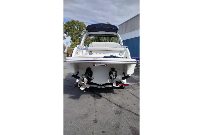 Slide: The Image of 2019 Formula 310 Bowrider boat, rear view, parked outdoors near a building. - 8