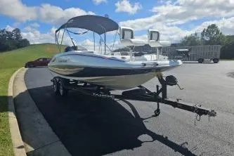 Slide: The Image of 2024 Tahoe 2150 boat on trailer in sunny parking lot. - 7