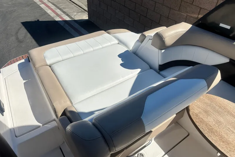 Slide: The Image of 2012 Regal 24 FasDeck boat interior with beige and white seating, outdoor setting. - 15