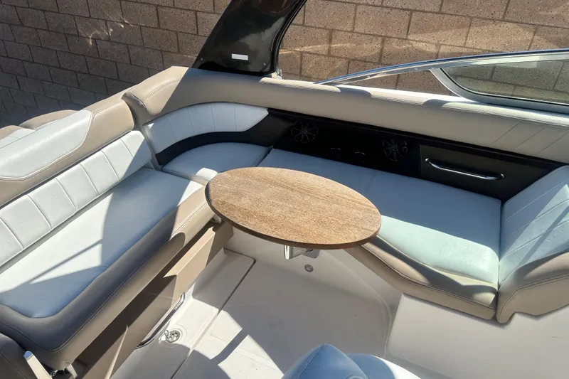 Slide: The Image of 2012 Regal 24 FasDeck boat interior with beige and white seating and wooden table. - 16