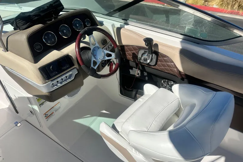 Slide: The Image of 2012 Regal 24 FasDeck boat interior with cushioned seating and a wooden table. - 18