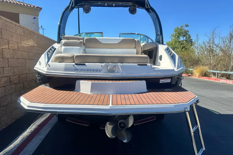 Slide: The Image of 2012 Regal 24 FasDeck boat with swim platform and ladder, parked outdoors. - 4