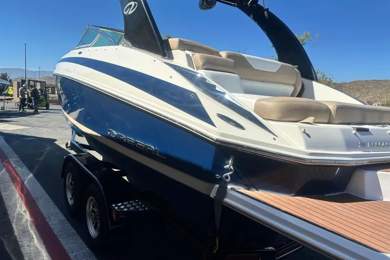 Slide: The Image of 2012 Regal 24 FasDeck boat on trailer, parked outdoors, sunny day. - 6