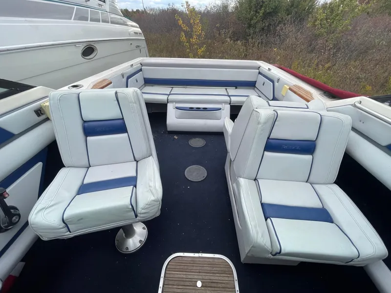 Slide: The Image of 1988 Regal boat interior with white and blue seating, spacious layout. - 19
