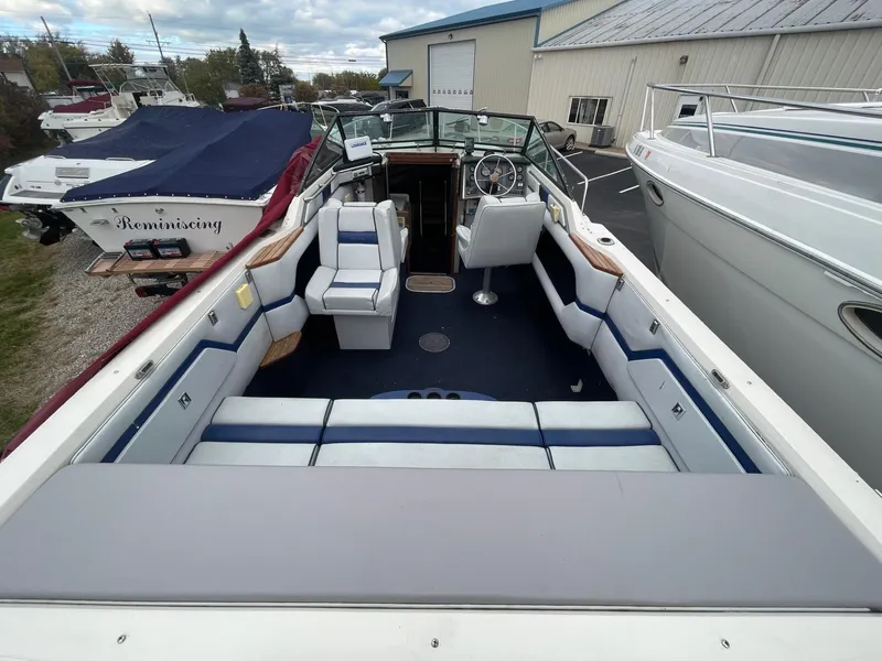 Slide: The Image of 1988 Regal boat interior with blue and white seating, docked near other boats. - 4