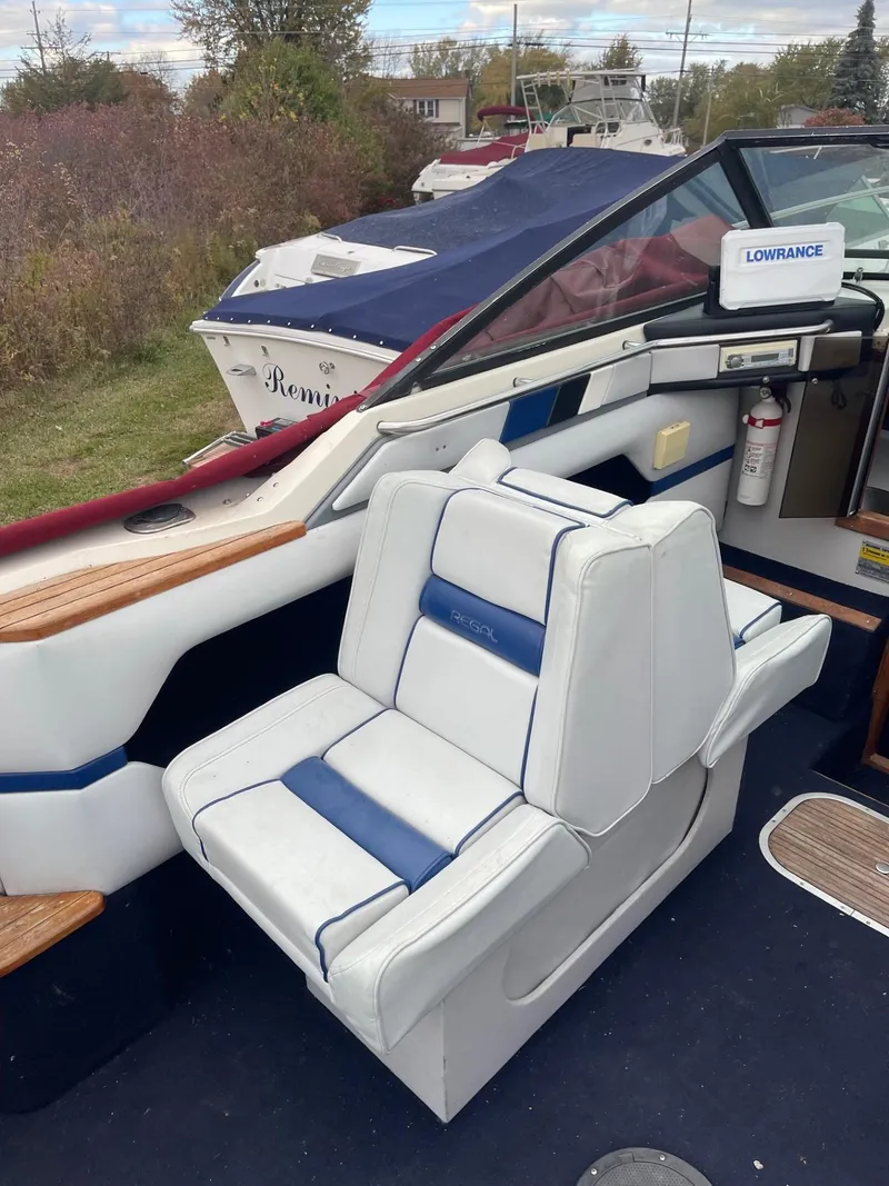 Slide: The Image of 1988 Regal boat interior with white and blue seating, Lowrance equipment visible. - 6