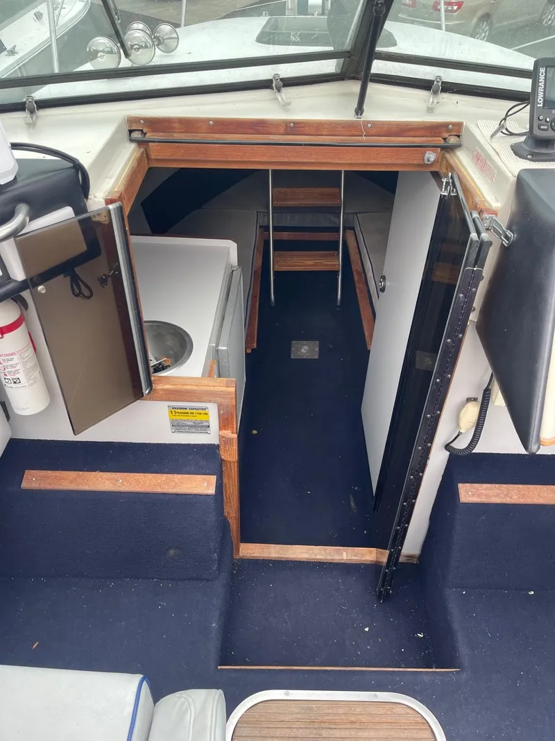 Slide: The Image of Interior view of 1988 Regal REGAL boat cabin with blue carpet and wooden accents. - 8