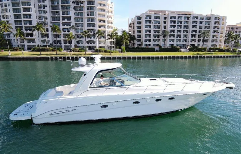 The Image of 2004 Sea Ray 460 Sundancer yacht cruising near waterfront buildings. - 0