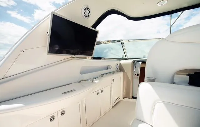 Slide: The Image of Interior of 2004 Sea Ray 460 Sundancer yacht with TV and white seating. - 11