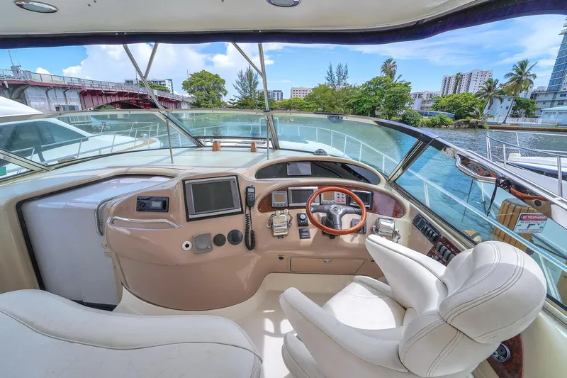 Slide: The Image of Helm of 2004 Sea Ray 460 Sundancer yacht with modern controls and scenic waterway view. - 12