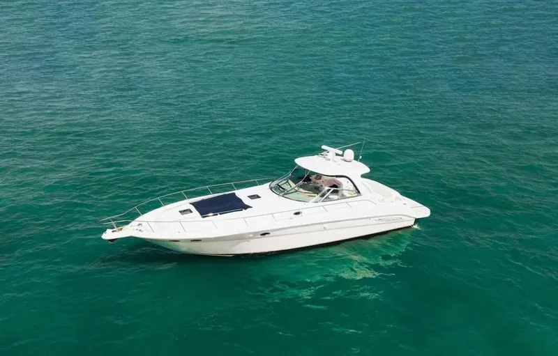 Slide: The Image of 2004 Sea Ray 460 Sundancer yacht cruising on clear turquoise waters. - 4