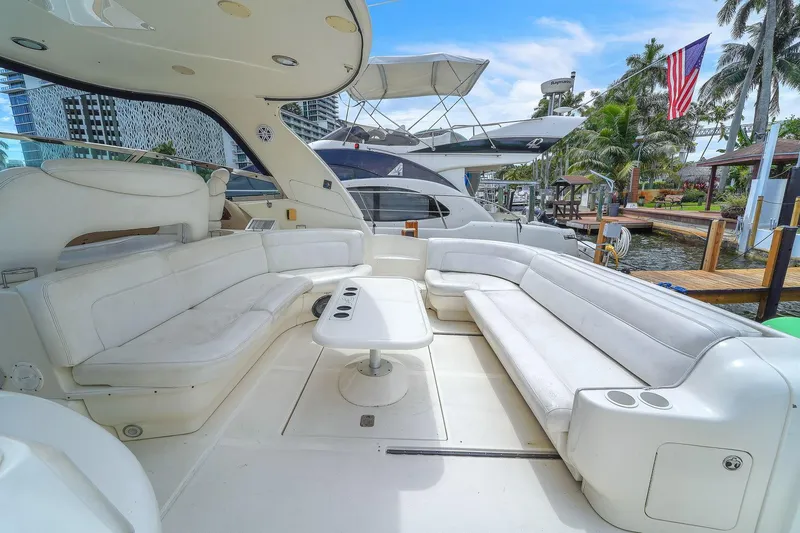 Slide: The Image of Luxurious 2004 Sea Ray 460 Sundancer yacht with spacious white seating area and table. - 8