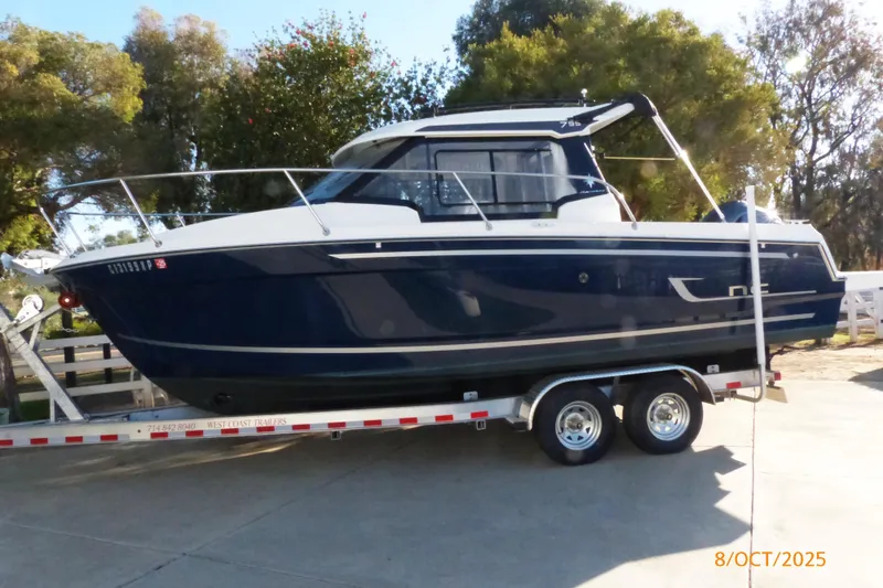 The Image of 2023 Jeanneau NC Weekender 795 Series 2 boat on trailer, parked outdoors. - 0