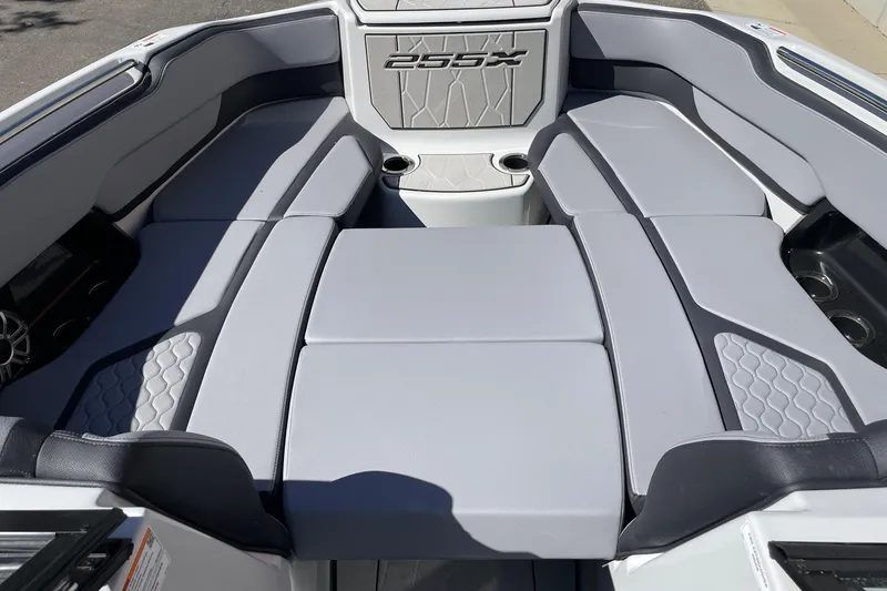 Slide: The Image of 2025 Yamaha Boats 255XD interior seating with gray upholstery and cup holders. - 11