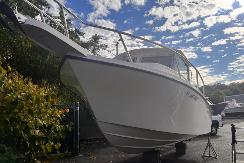 Slide: The Image of 2007 Parker 2320 SL Sport Cabin boat on stands under a partly cloudy sky. - 3