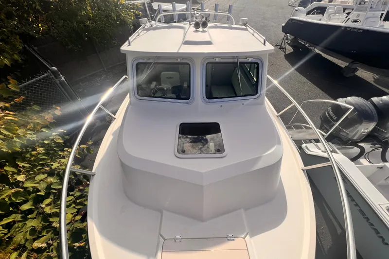 Slide: The Image of 2007 Parker 2320 SL Sport Cabin boat, top view, docked with surrounding foliage. - 9