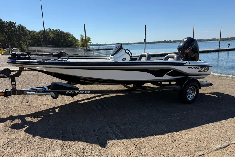 Slide: The Image of 2016 Nitro Z18 boat on trailer, parked near grassy field, with pickup truck. - 33
