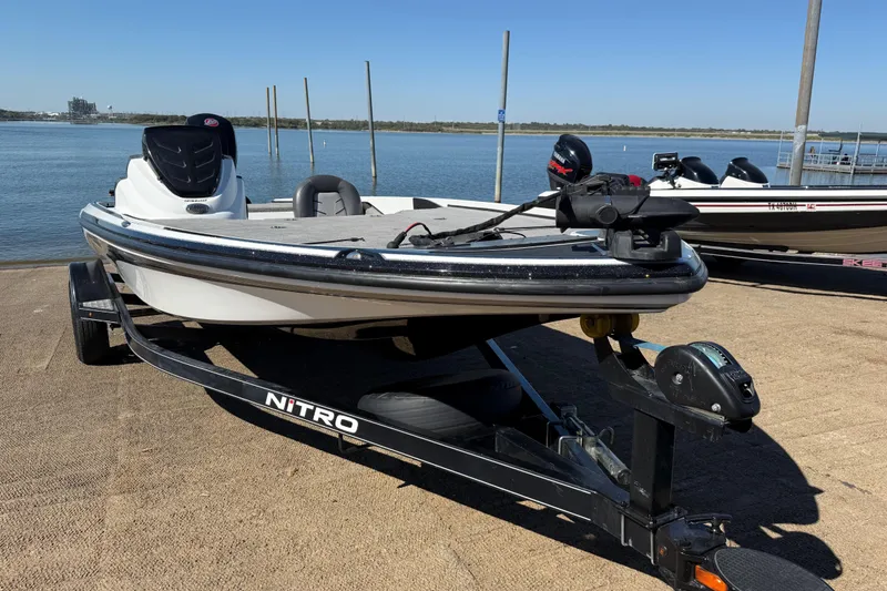 Slide: The Image of 2016 Nitro Z18 Pro fishing boat docked by a serene lake. - 49