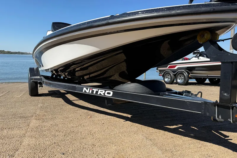 Slide: The Image of 2016 Nitro Z18 Pro boat with dual seats, docked by a serene lake. - 50