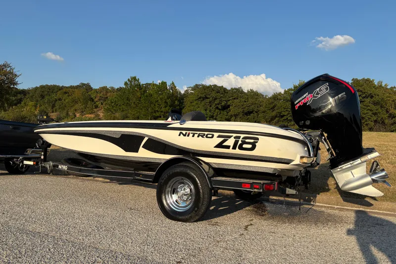 Slide: The Image of 2016 Nitro Z18 Pro boat on trailer, parked near red truck, sunny day. - 6
