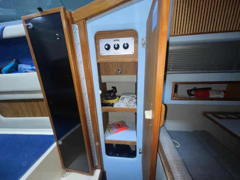 Slide: The Image of 1988 Sea Ray 268 Cruiser interior with open wooden cabinet and shelves. - 17