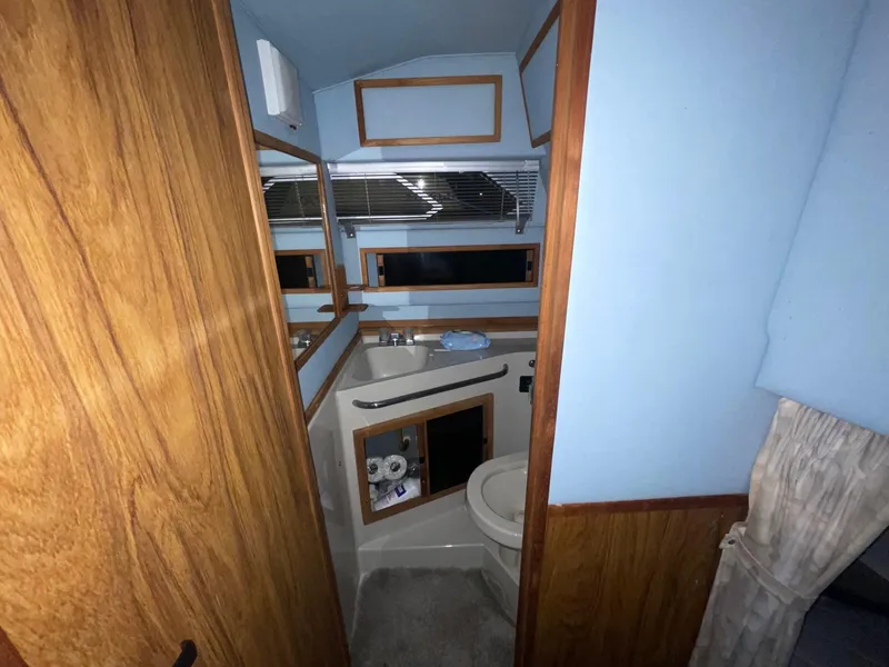 Slide: The Image of 1988 Sea Ray 268 Cruiser bathroom with wood accents and compact design. - 20