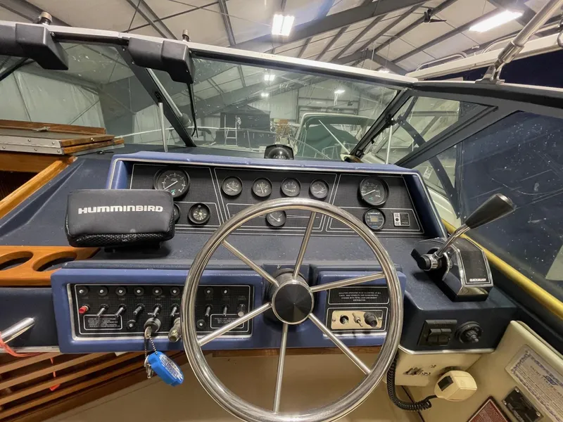 Slide: The Image of 1988 Sea Ray 268 Cruiser dashboard with steering wheel and Humminbird device. - 9
