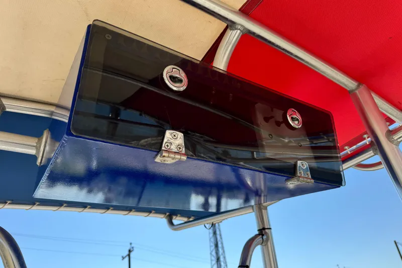 Slide: The Image of 2016 Blue Wave 2200 STL RISER boat console with red canopy and storage compartment. - 10