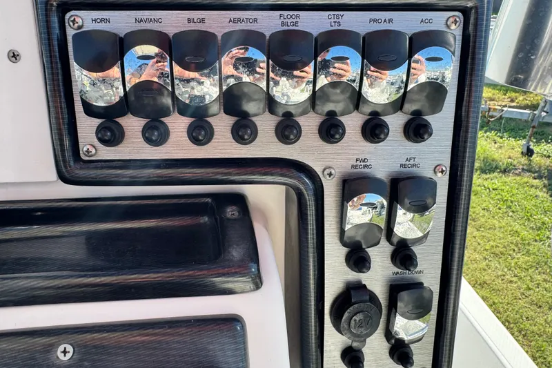 Slide: The Image of Control panel of a 2016 Blue Wave 2200 STL RISER boat with various switches. - 12