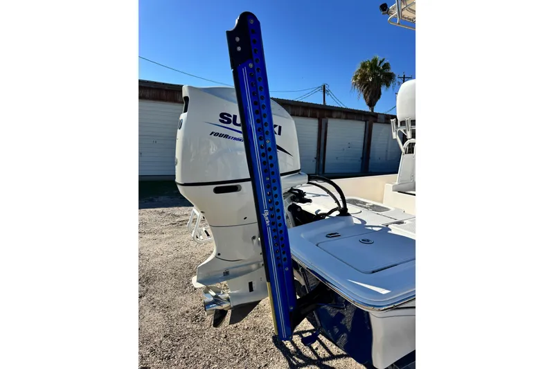 Slide: The Image of 2016 Blue Wave 2200 STL RISER boat with Suzuki outboard motor, parked outdoors. - 4