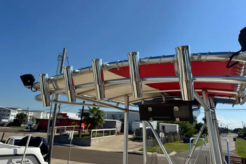 Slide: The Image of 2016 Blue Wave 2200 STL RISER boat with stainless steel rod holders and red canopy. - 46