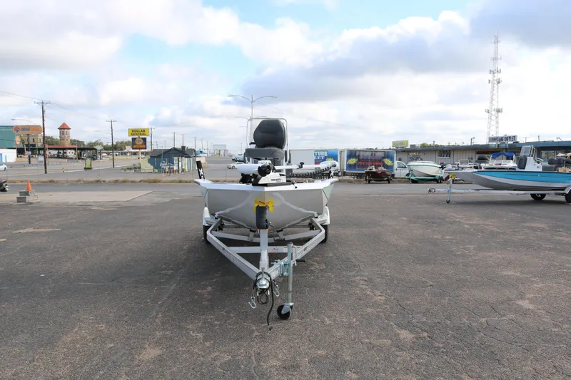 Slide: The Image of 2026 Xpress H20B Bay boat on trailer in parking lot, cloudy sky background. - 2