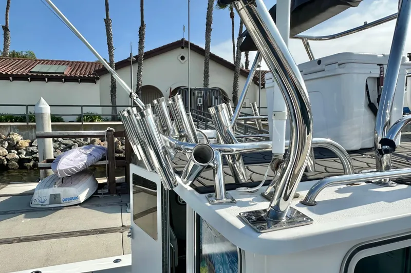 Slide: The Image of 2014 Parker 2530 Extended Cabin boat with rod holders at a marina dock. - 14
