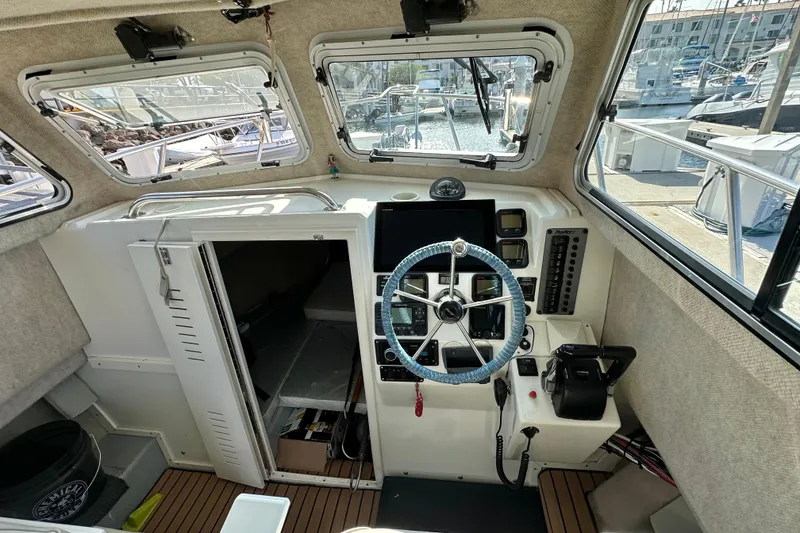 Slide: The Image of 2014 Parker 2530 Extended Cabin boat interior with steering wheel and control panel. - 18