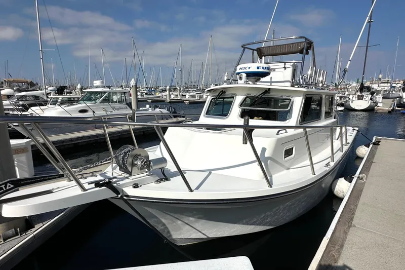 Slide: The Image of 2014 Parker 2530 Extended Cabin boat docked in a marina under a clear sky. - 2