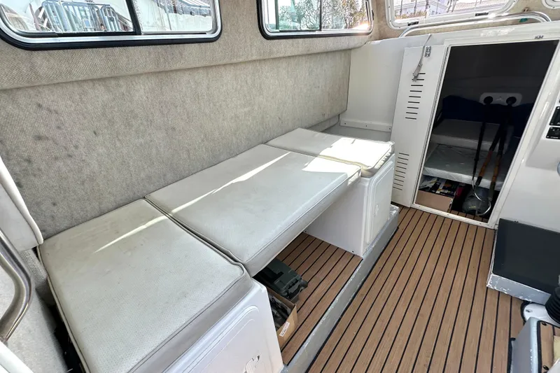 Slide: The Image of 2014 Parker 2530 Extended Cabin interior with cushioned seating and wooden flooring. - 21