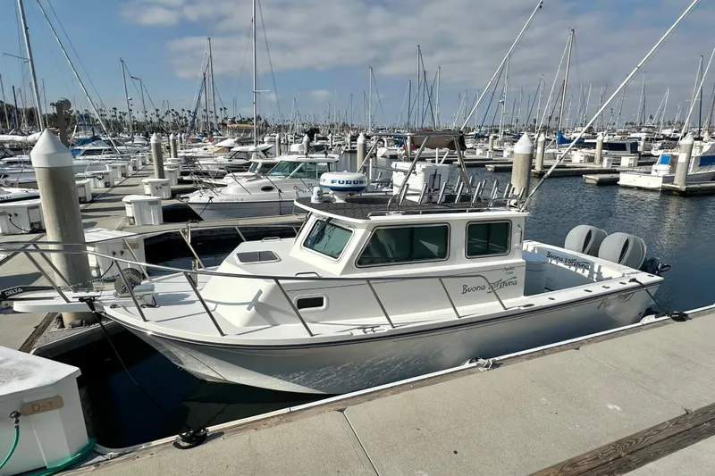 Slide: The Image of 2014 Parker 2530 Extended Cabin boat docked in a marina with sailboats. - 3