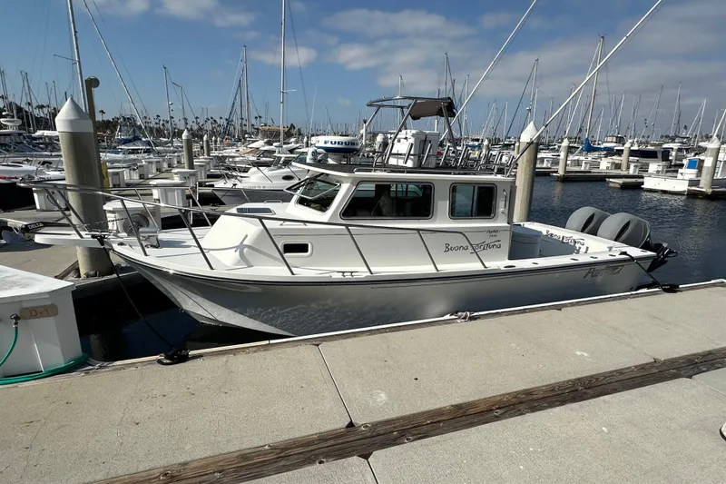 Slide: The Image of 2014 Parker 2530 Extended Cabin boat docked in a marina, surrounded by sailboats. - 4